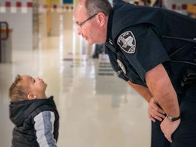 Officer talking to young kindergarten student 